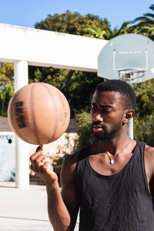 Black man spinning basketball on finger