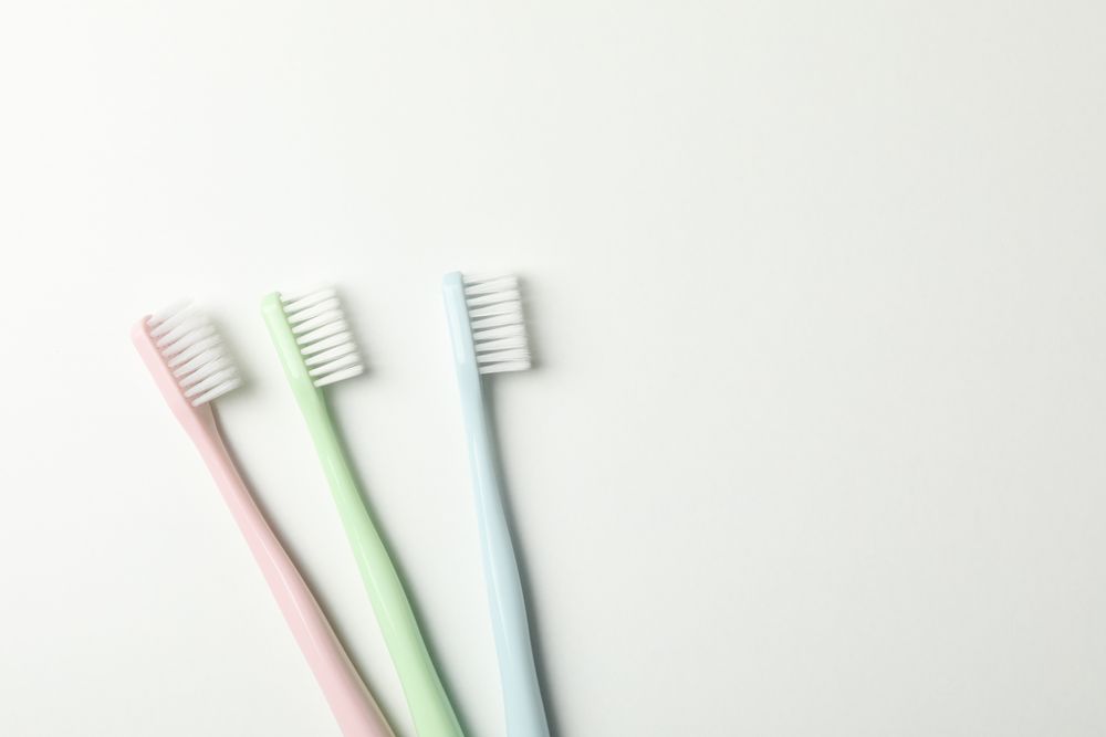 Toothbrushes on light background, top view. Dental care