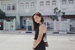 Side view of woman in dark dress posing outdoor