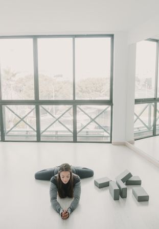 Flexible woman stretching in studio