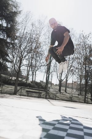 Young man in air dancing break dance in park
