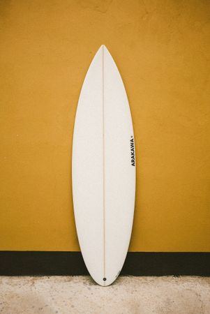 Surfboard against a yellow wall