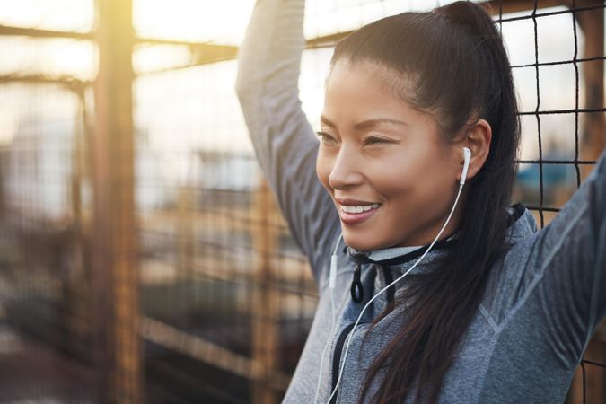 Happy woman in workout gear with arms above head