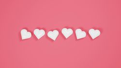Plastic hearts on pink background