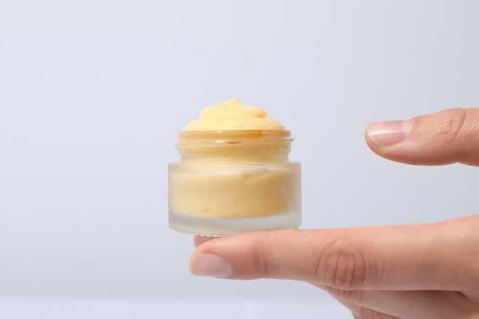 A jar of hand cream on a light background.