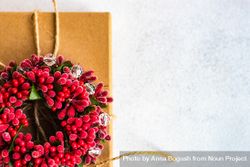Holiday gift with red holly wreath and string 0LxJX0