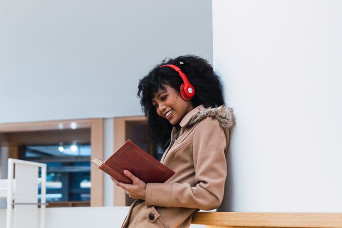Content female student reading textbook in library