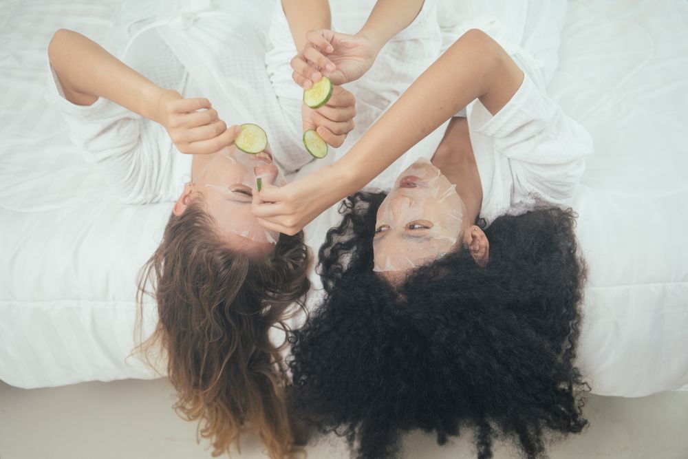 Women in bathrobe doing facial treatment with mask sheet