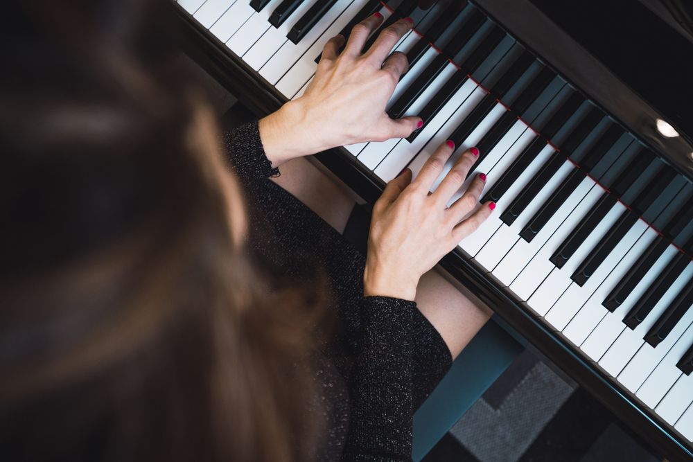 Top view of cropped hands playing the piano