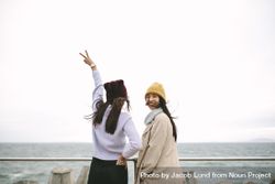 Rear view of two women standing by sea in winter clothes 4mdZz5