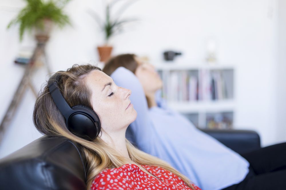 Two women lying back and relaxing in living room