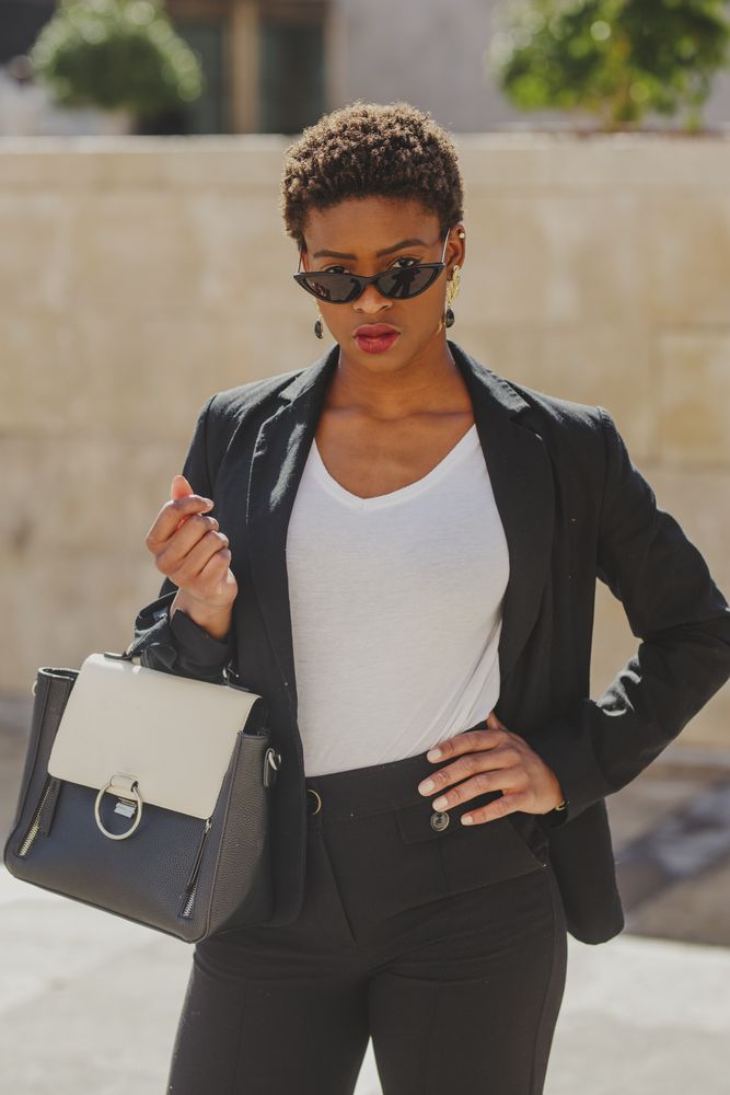 Stylish Black woman with handbag and sunglasses on street
