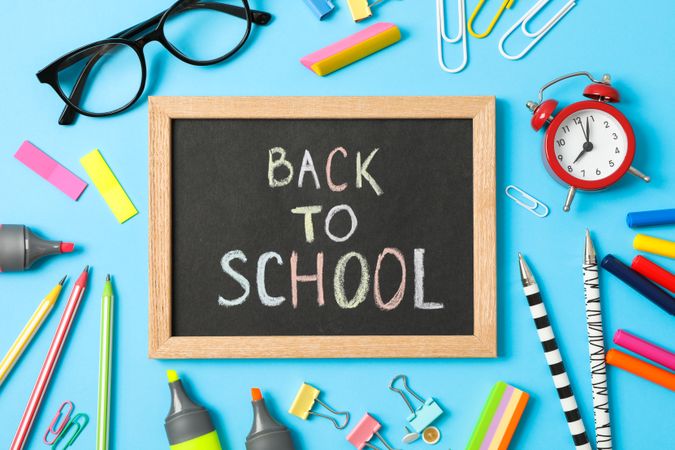 Composition with school supplies and inscription back to school on color background