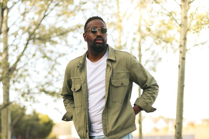 Black young man with sunglasses walking in a park