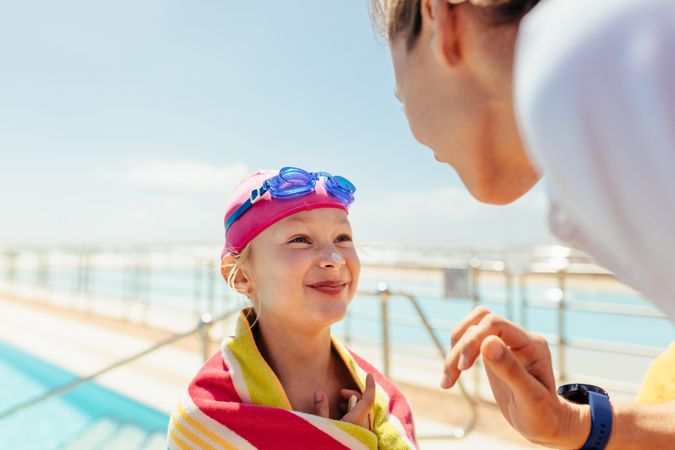 Coach putting sunscreen on child’s nose