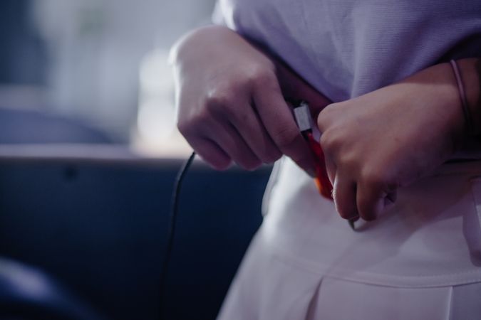 Detail shot of a person connecting electronic charger to device