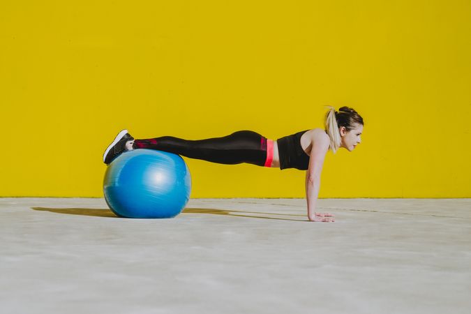 Woman doing plank with legs on ball