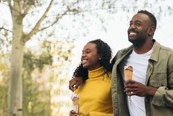 Black couple eating ice cream in a park