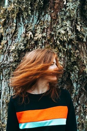 Casual redhead woman shaking with hair