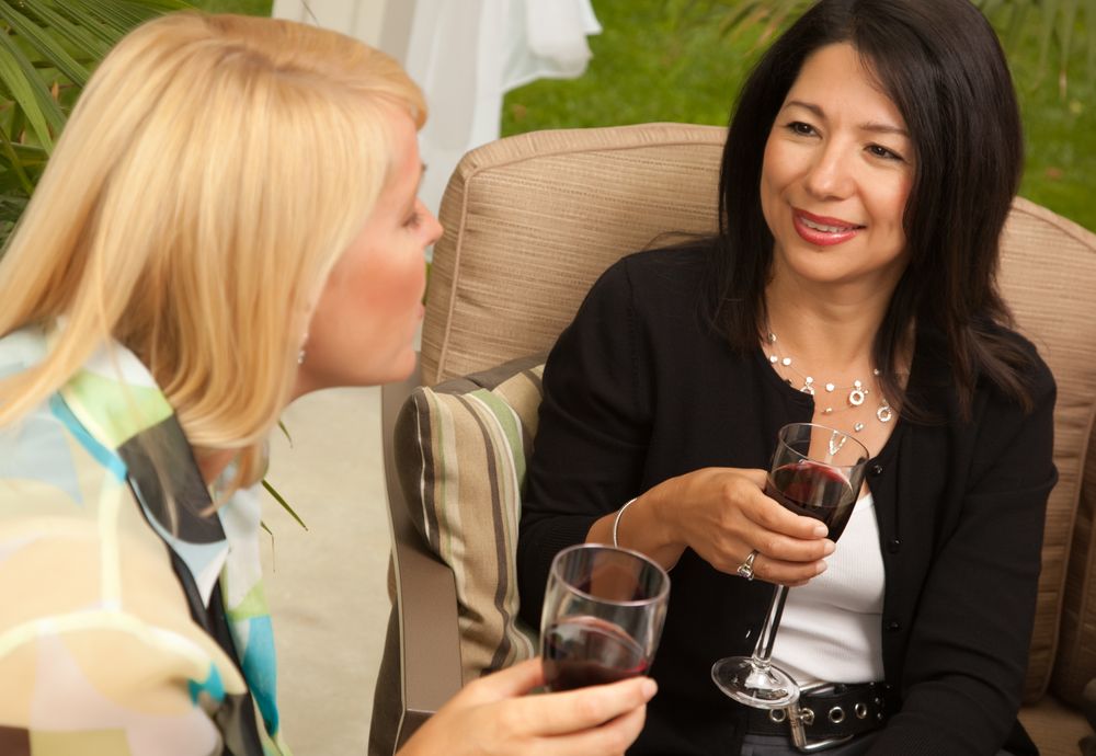 Two Girlfriends Enjoy Wine on the Patio