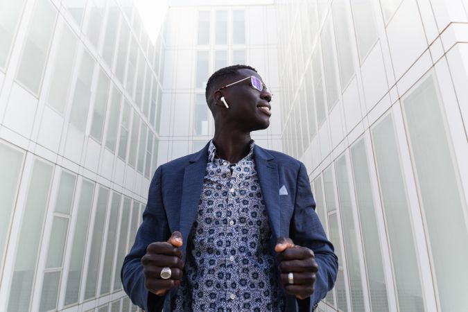 Content Black businessman listening to music in earbuds in city