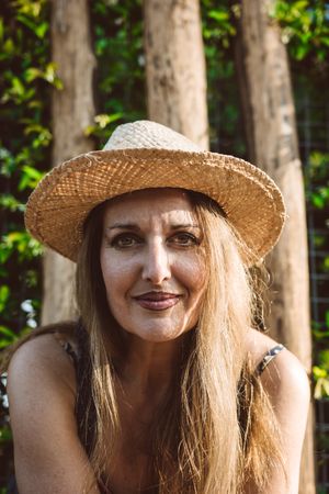 Smiling woman in straw hat looking away