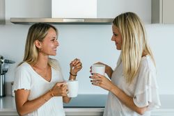 Women with coffee chatting in kitchen