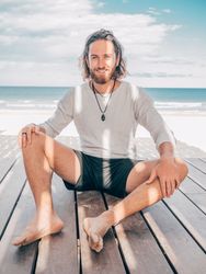 Man sitting on wooden pier on the beach