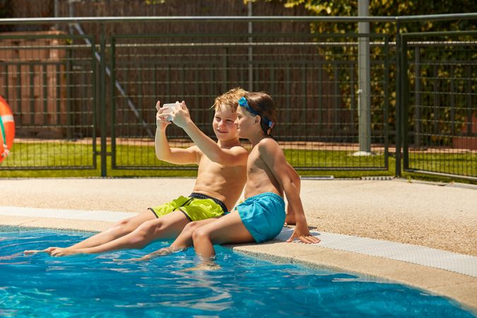 Boys on poolside taking selfie