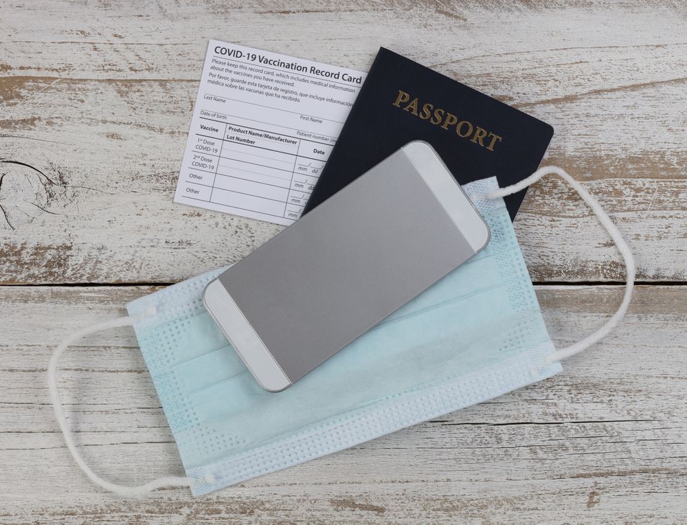 Covid 19 vaccination record card with US passport other basic travel items in close up format