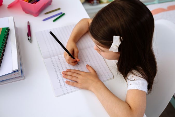Girl doing homework sitting at a desk