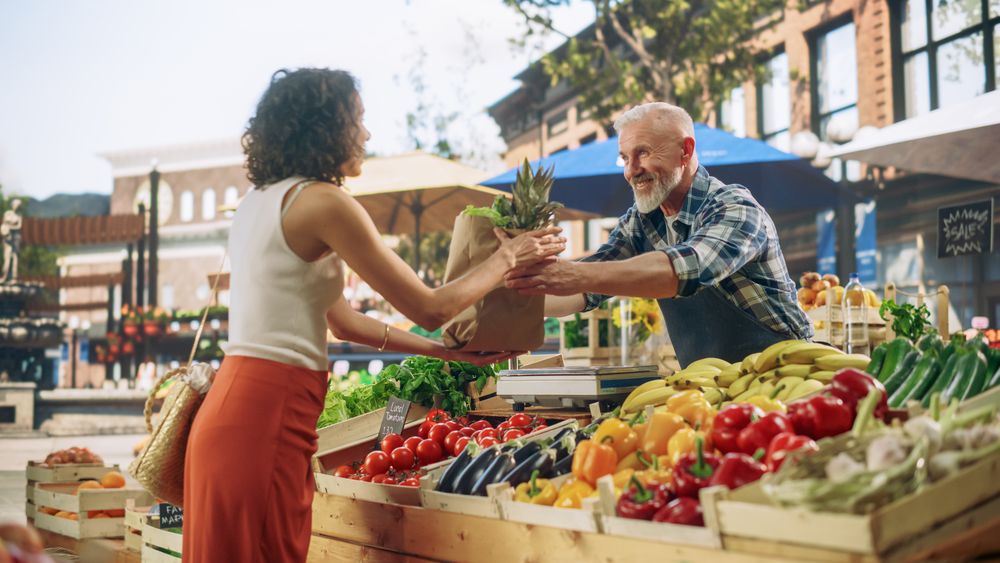 Cheerful Street Vendor Running a Small Farm Market Business, Selling Sustainable Fruits and Vegetables.