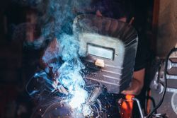 Professional welder in mask welding metal