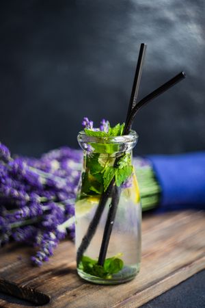 Side view of lemonade with lavender, lemon and mint with straws