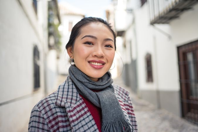 Joyful female tourist in casual wear amid city street