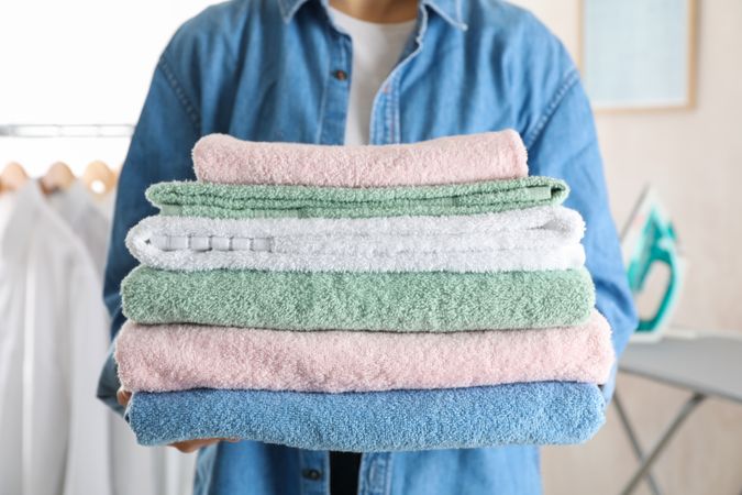 Young woman hold clean towels, close up and space for text