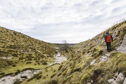 Man walking on hill near valley
