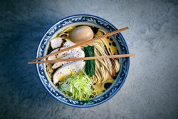 Delicious ramen with chicken fillet slices and chopsticks