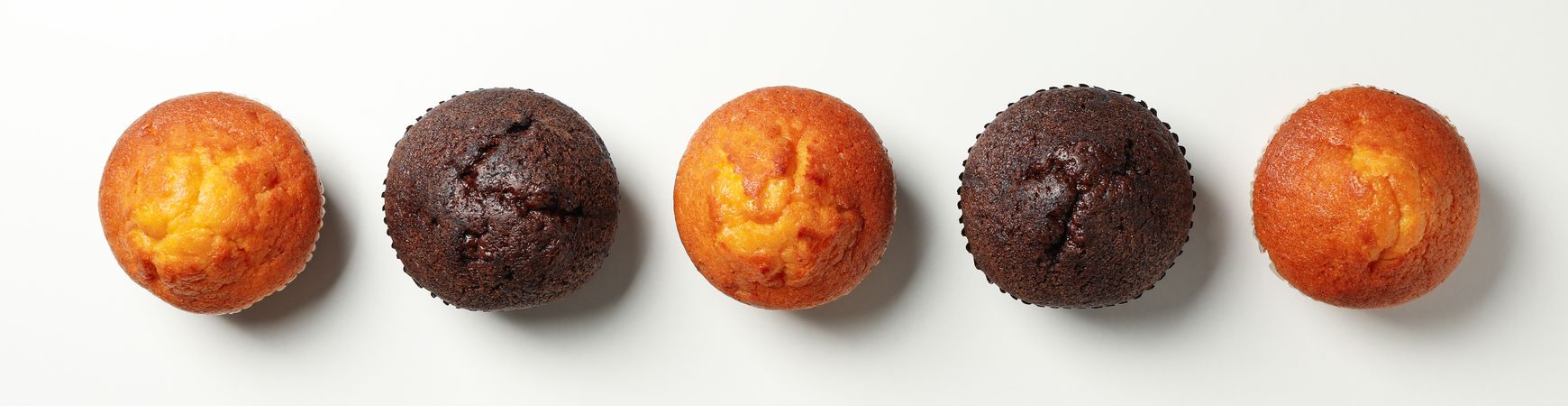 Flat lay with tasty muffins on light background, top view