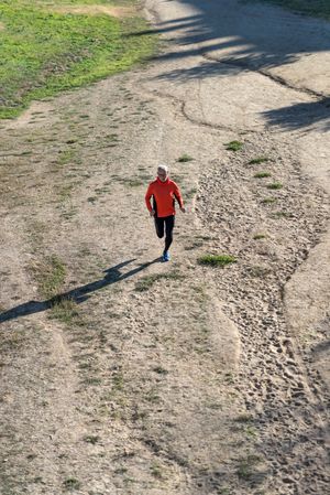 Looking down at male jogging through track in the park