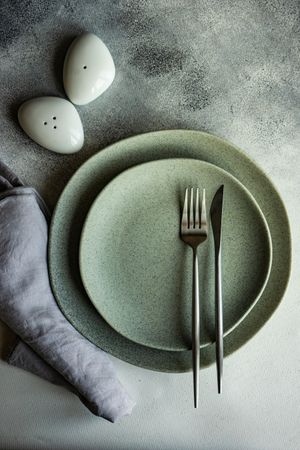 Elegant modern table setting, napkin, cutlery with salt and pepper shakers