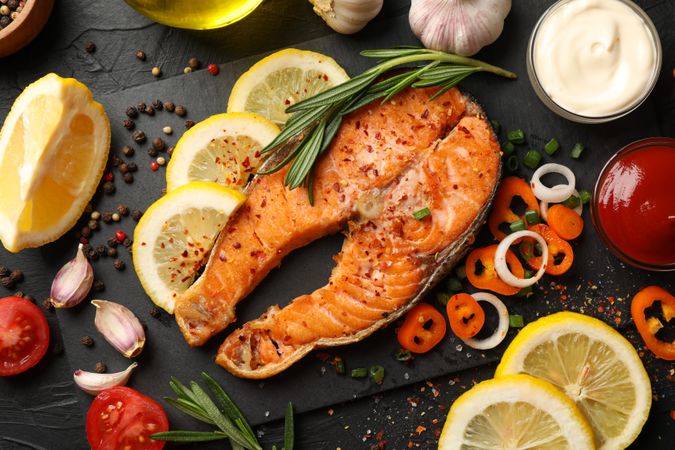 Composition with tasty grilled salmon on dark background, top view
