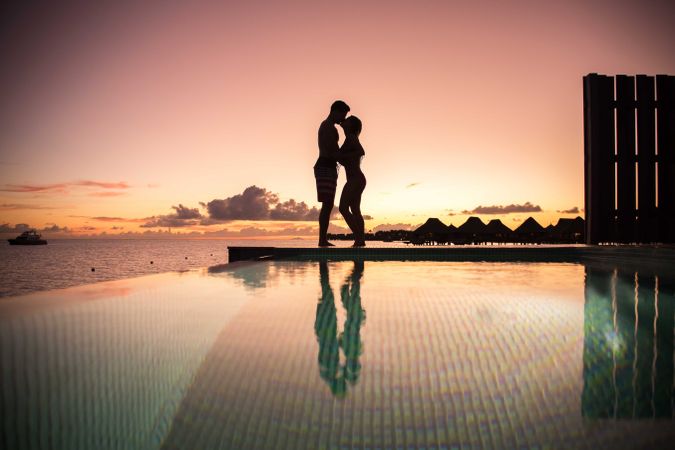 Silhouette of man and woman kissing each other during sunset