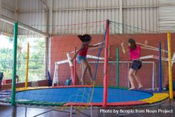 Two young girls jumping on trampoline bGQ6l5