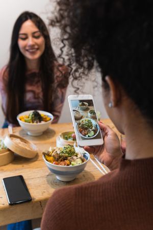Woman taking photo of dish in restaurant
