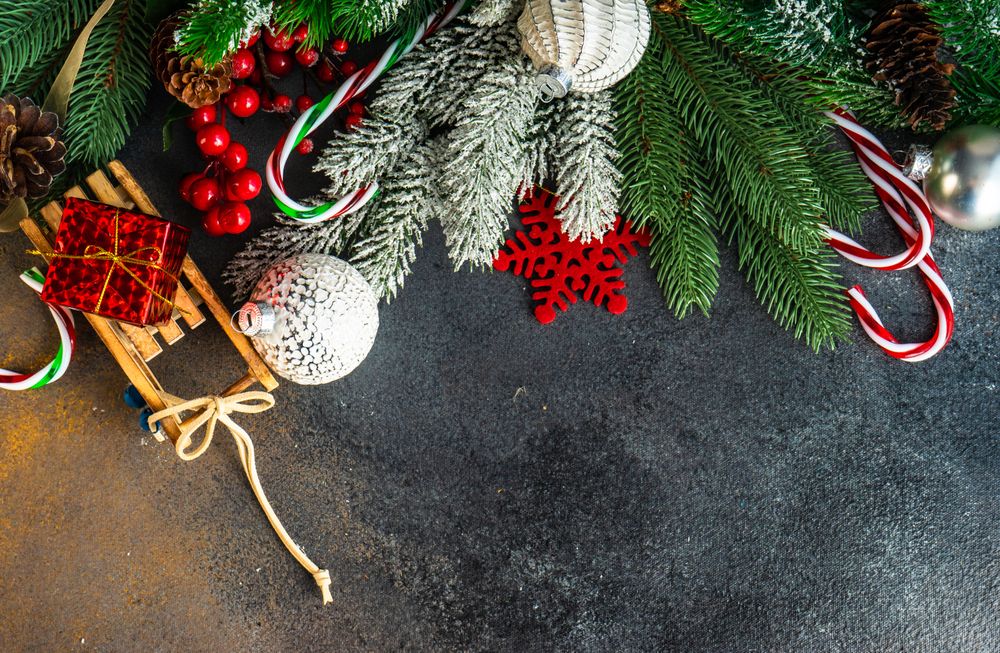 Top view of fir and holiday decorations on dark table