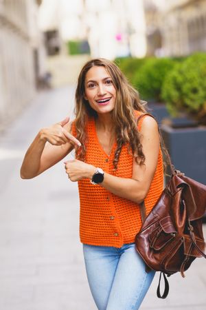 Woman complaining about time pointing her wrist watch outdoors
