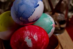 Set of painted Easter eggs in container on table