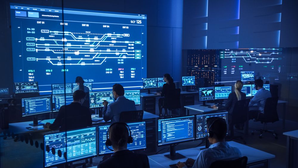 Multicultural Team in a Futuristic Control Room Monitors Complex Data Streams on Multiple Screens, Ensuring Seamless Cybersecurity