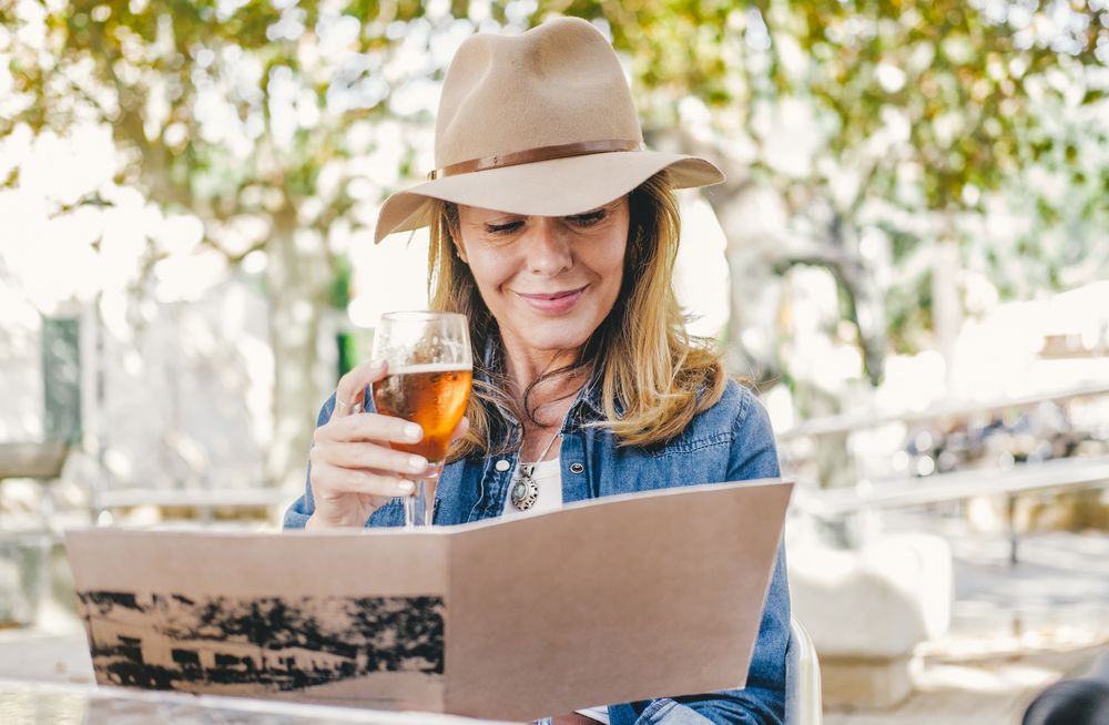 Woman sitting outside cafe drinking beer